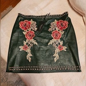 Green faux leather studded mini skirt with emboridered flowers